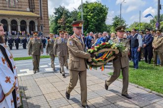 Gardă de onoare și oficialități depunând coroane de flori la Monumentul Crucificării din Timișoara, de Ziua Eroilor.
