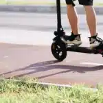 O trotinetă electrică abandonată pe marginea drumului, ilustrând pericolul accidentelor în care sunt implicați minorii.