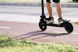 O trotinetă electrică abandonată pe marginea drumului, ilustrând pericolul accidentelor în care sunt implicați minorii.