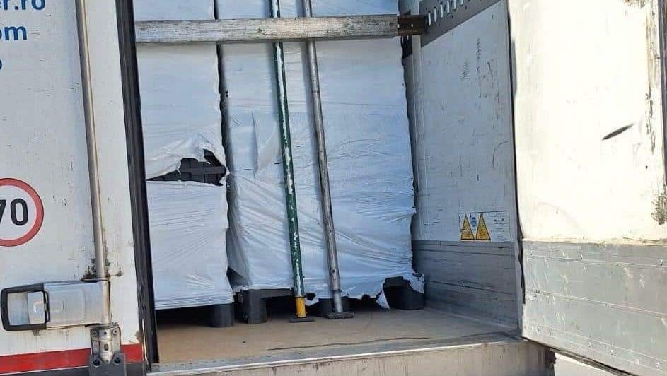 Polițiști verificând remorca unui TIR plin cu baxuri de țigări de contrabandă pe autostrada A1.