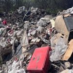 Polițiști lângă o autoutilitară confiscată după ce șoferul a aruncat 4 tone de deșeuri pe un câmp din Arad.
