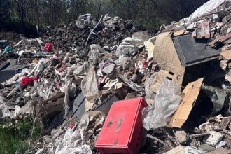 Polițiști lângă o autoutilitară confiscată după ce șoferul a aruncat 4 tone de deșeuri pe un câmp din Arad.