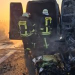 Pompieri stingând flăcările la o autoutilitară de transport mobilier pe banda de urgență a autostrăzii A1.