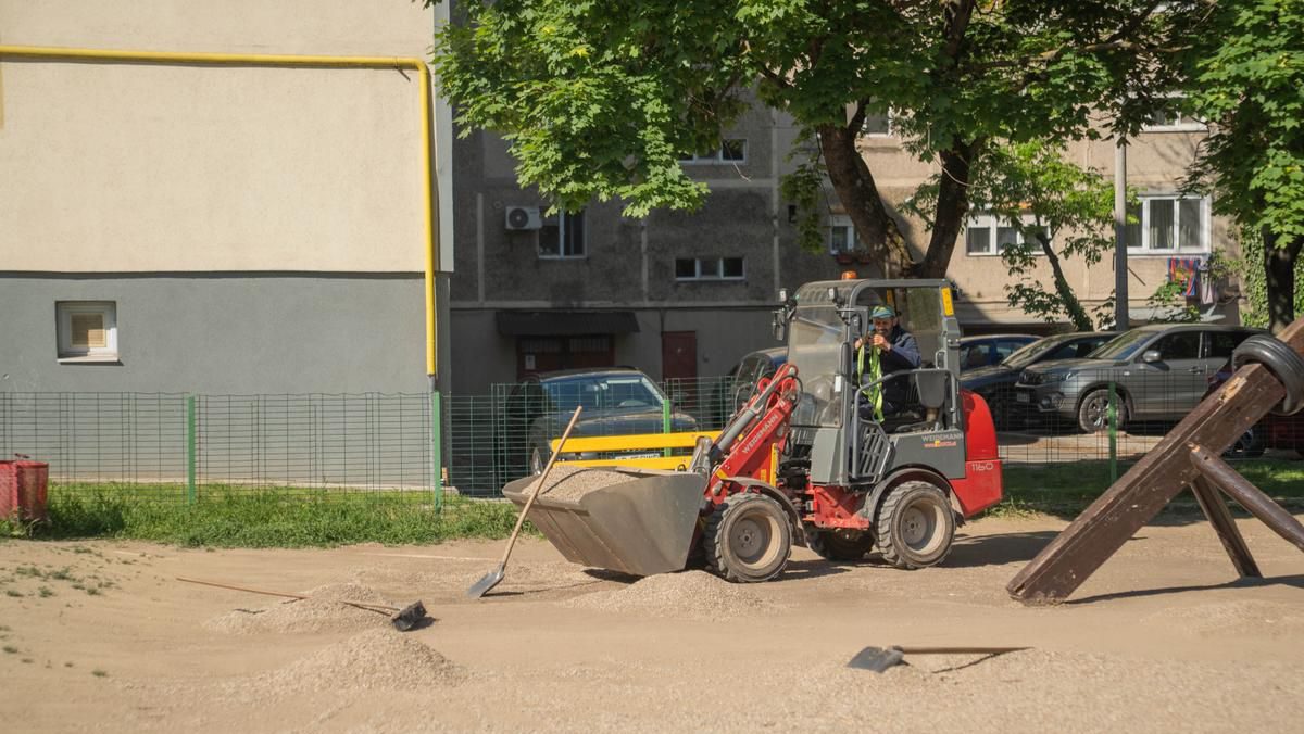 Muncitori lucrând la amenajarea noului loc de joacă de pe strada Orșova din Timișoara, unde se montează echipamente noi și suprafețe de protecție.