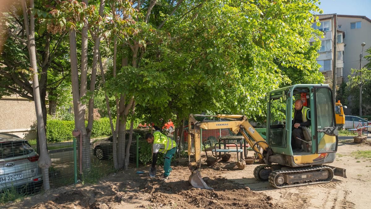Muncitori lucrând la amenajarea noului loc de joacă de pe strada Orșova din Timișoara, unde se montează echipamente noi și suprafețe de protecție.