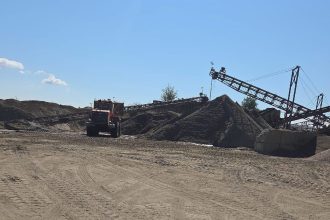 Specialiști efectuând măsurători topometrice pe marginea unei gropi de împrumut dintr-o balastieră din județul Arad, pentru verificarea perimetrului de exploatare.