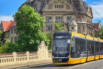 Tramvai de pe linia 5 circulând prin Timișoara; anunț privind restricțiile din Piața Traian până în august 2026.