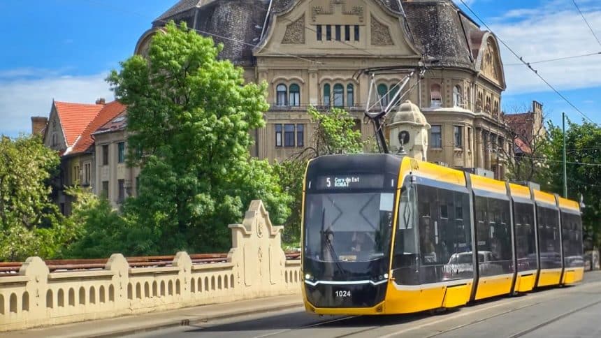 Tramvai de pe linia 5 circulând prin Timișoara; anunț privind restricțiile din Piața Traian până în august 2026.