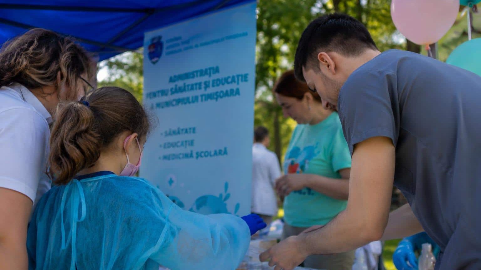 Copil care învață să folosească stetoscopul prin joacă la evenimentul Supereroii Sănătății din Timișoara.
