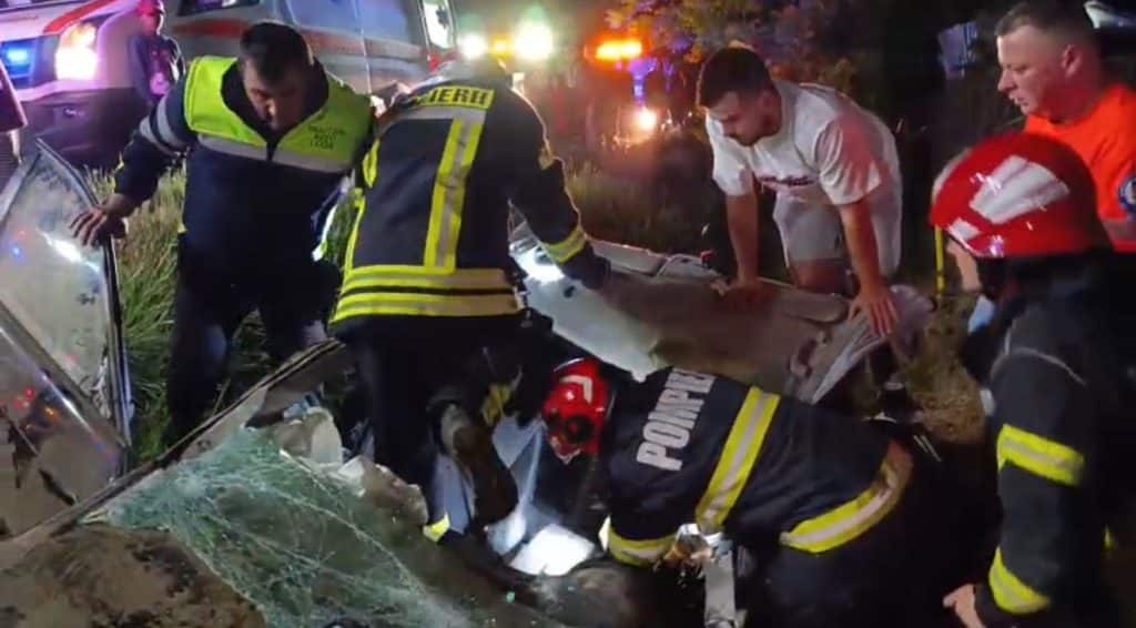Autoturism răsturnat în șanț pe DN58B lângă Câlnic; pompieri și echipa de intervenție gaze la locul accidentului.