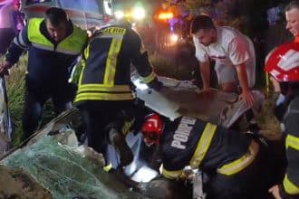 Autoturism răsturnat în șanț pe DN58B lângă Câlnic; pompieri și echipa de intervenție gaze la locul accidentului.