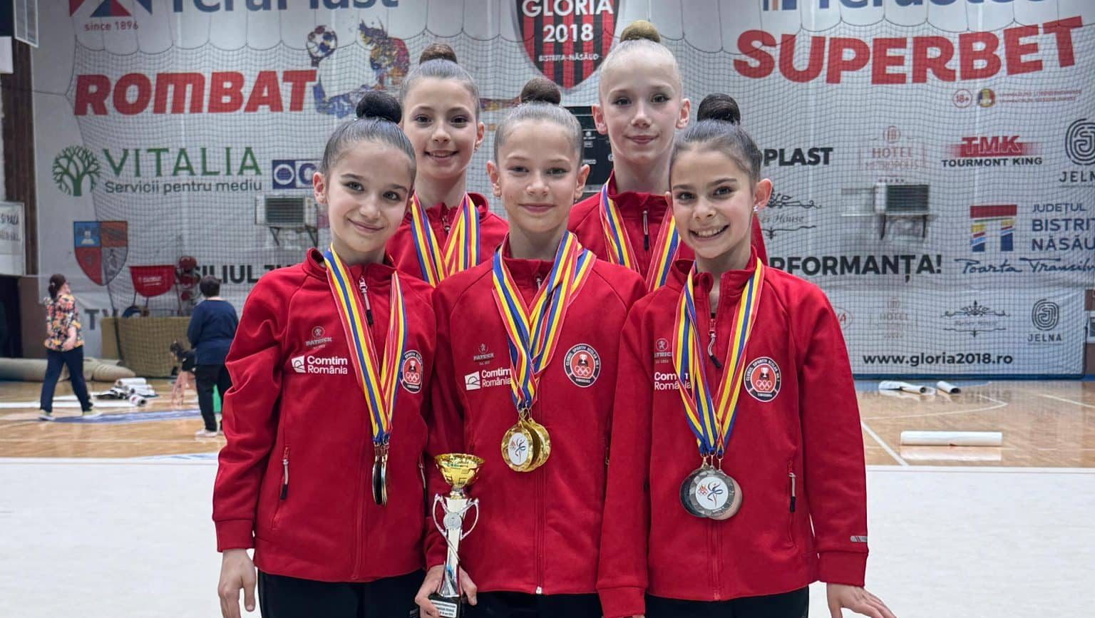 Gimnastele de la CSS nr. 1 Timișoara pe podium la Campionatul Național Școlar de la Bistrița, alături de antrenoarele Monica Wurtz și Alexandrina Tartan.