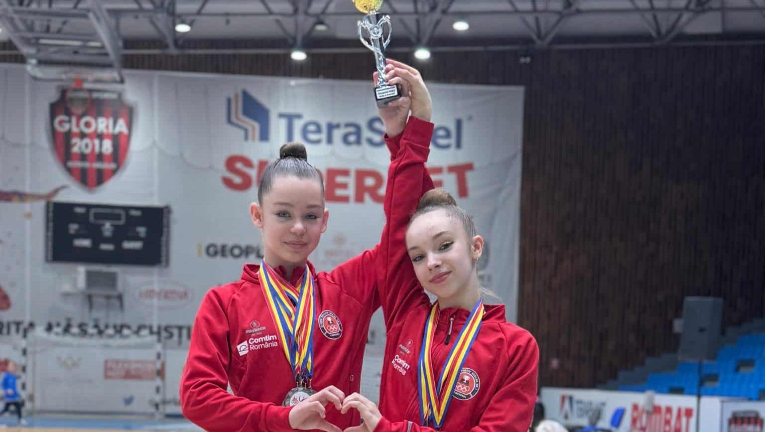 Gimnastele de la CSS nr. 1 Timișoara pe podium la Campionatul Național Școlar de la Bistrița, alături de antrenoarele Monica Wurtz și Alexandrina Tartan.