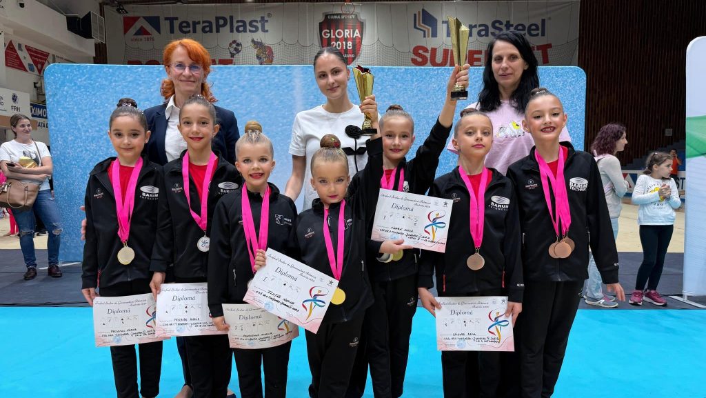 Gimnastele de la CSS nr. 1 Timișoara pe podium la Campionatul Național Școlar de la Bistrița, alături de antrenoarele Monica Wurtz și Alexandrina Tartan.