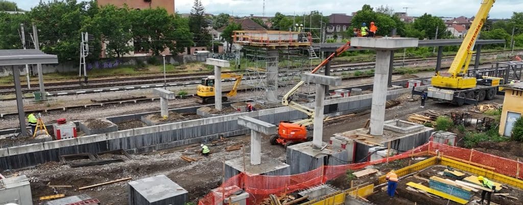 Muncitori montând structura metalică a noii pasarele pietonale dotată cu lifturi în stația CFR Timișoara Est.