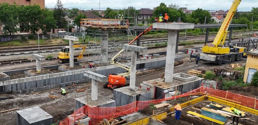 Muncitori montând structura metalică a noii pasarele pietonale dotată cu lifturi în stația CFR Timișoara Est.