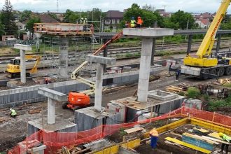Muncitori montând structura metalică a noii pasarele pietonale dotată cu lifturi în stația CFR Timișoara Est.