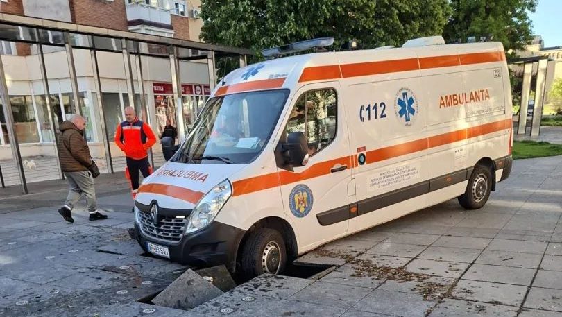 Autospecială de ambulanță rămasă blocată după ce dalele de pavaj de lângă o fântână arteziană din Arad au cedat sub greutatea mașinii.