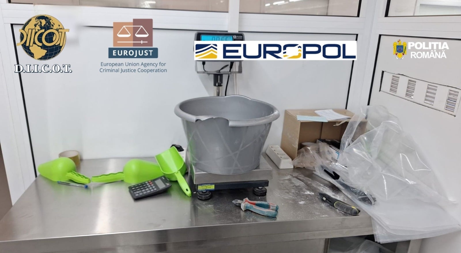 Polițiști și procurori DIICOT examinând sute de cutii cu suplimente alimentare false confiscate în urma perchezițiilor din mai 2026.