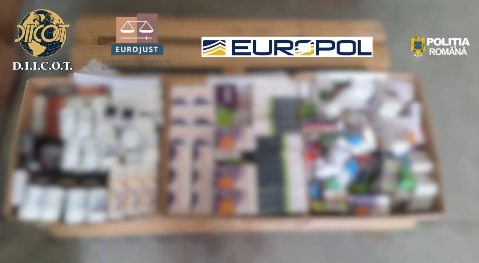 Polițiști și procurori DIICOT examinând sute de cutii cu suplimente alimentare false confiscate în urma perchezițiilor din mai 2026.