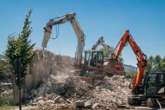 Imagine cu șantierul de la Podul Muncii din Timișoara unde utilajele demontează segmentele vechi de beton deasupra canalului Bega.