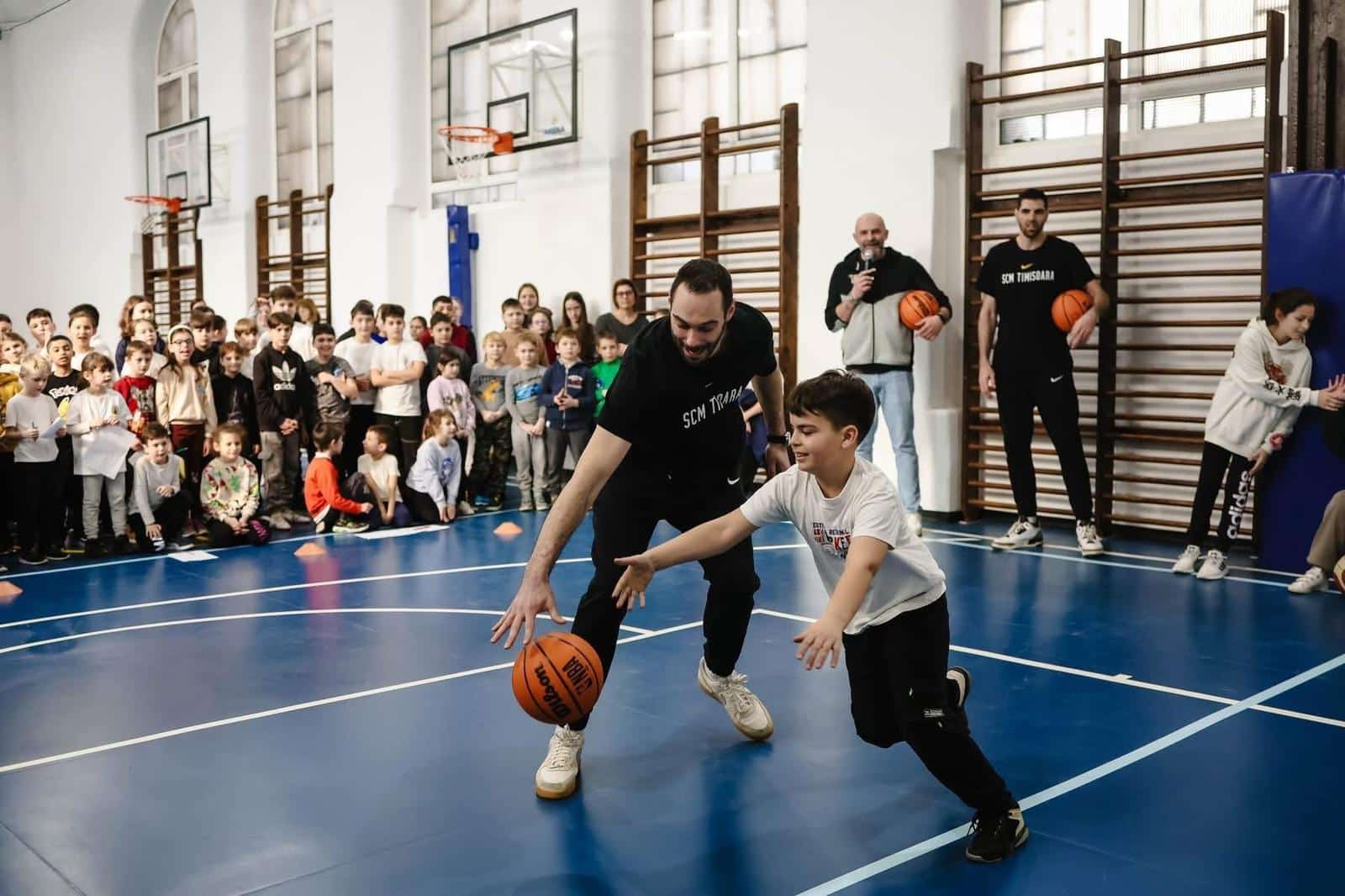 Copii participând la antrenamente de sport în aer liber sub îndrumarea antrenorilor de la SCM Timișoara.