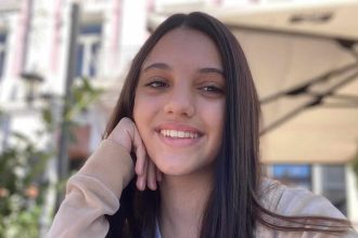 Portretul Antoniei Dumitru, minora de 14 ani dispărută din Timișoara, purtând haine roșii și hanorac negru.