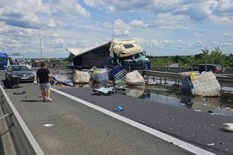 Imagine de la locul accidentului de pe autostrada A1 Arad unde un TIR are cabina distrusă și marfa este împrăștiată pe carosabil.
