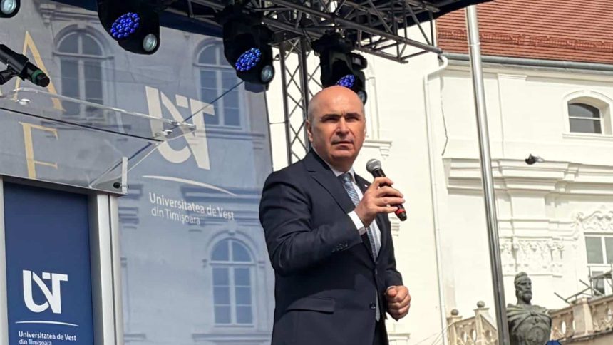 Premierul interimar Ilie Bolojan vorbind pe scenă în fața sutelor de absolvenți ai Universității de Vest din Timișoara adunați în Piața Libertății.