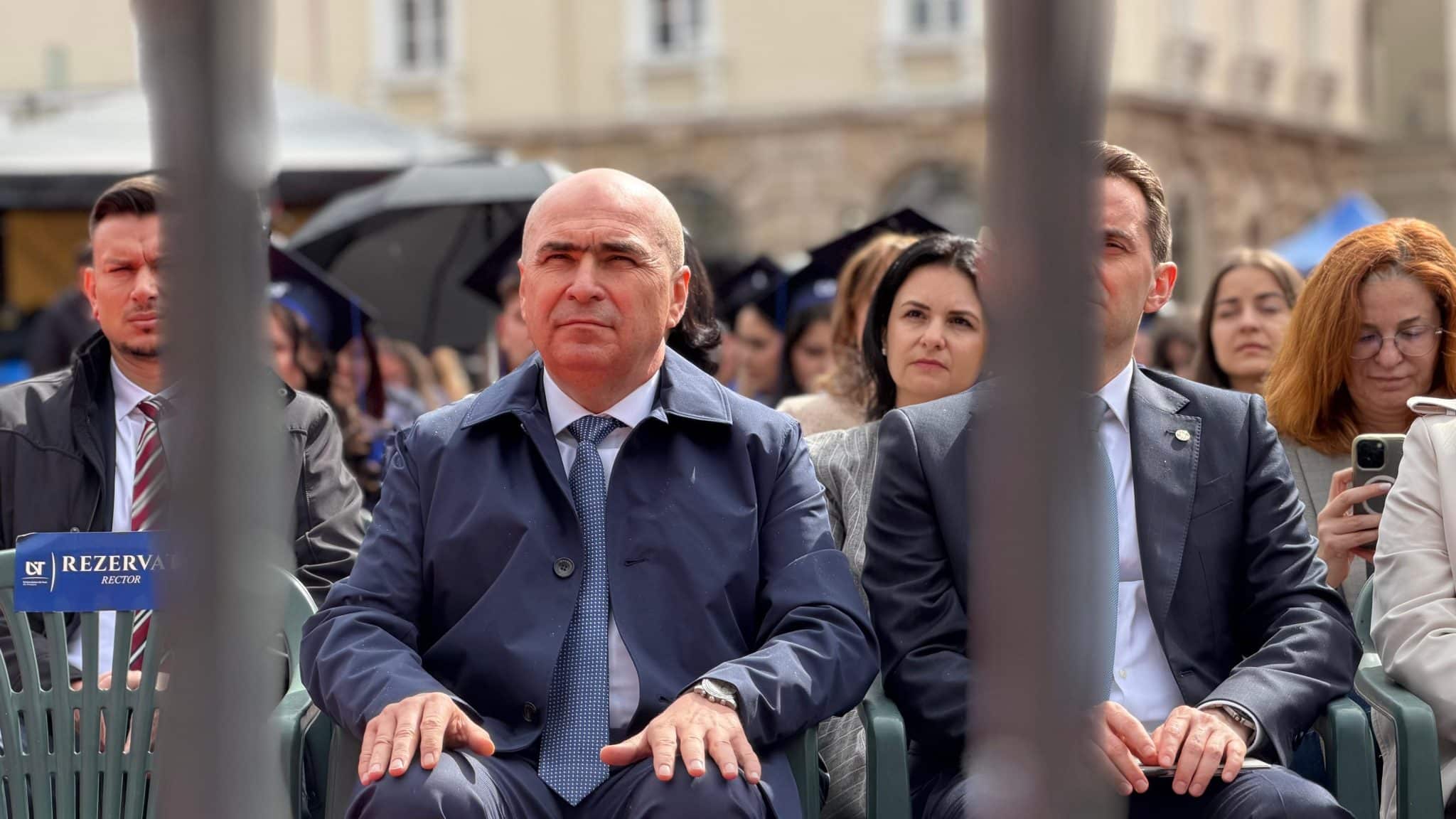 Premierul interimar Ilie Bolojan vorbind pe scenă în fața sutelor de absolvenți ai Universității de Vest din Timișoara adunați în Piața Libertății.