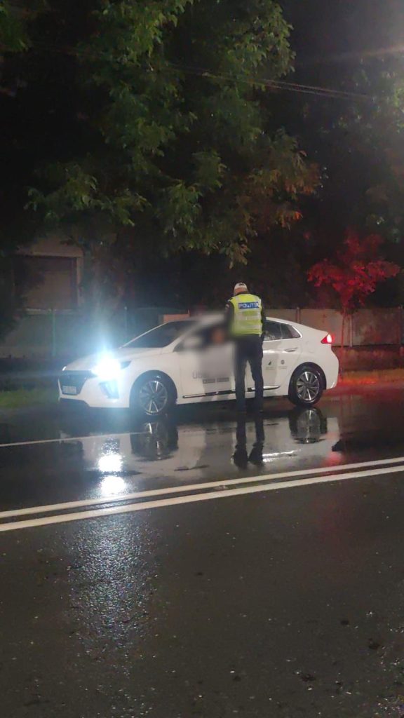 Filtru de control al Poliției Rutiere Timiș pe o stradă din Timișoara pe timp de noapte, verificând actele unui șofer.