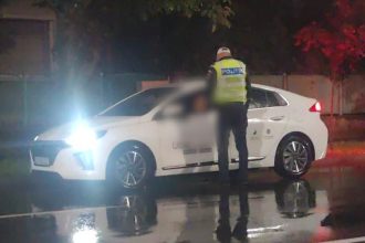 Filtru de control al Poliției Rutiere Timiș pe o stradă din Timișoara pe timp de noapte, verificând actele unui șofer.