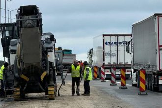 Utilaje de asfaltare și conuri de semnalizare rutieră pe o bandă restricționată a autostrăzii A1 în zona de vest a României.