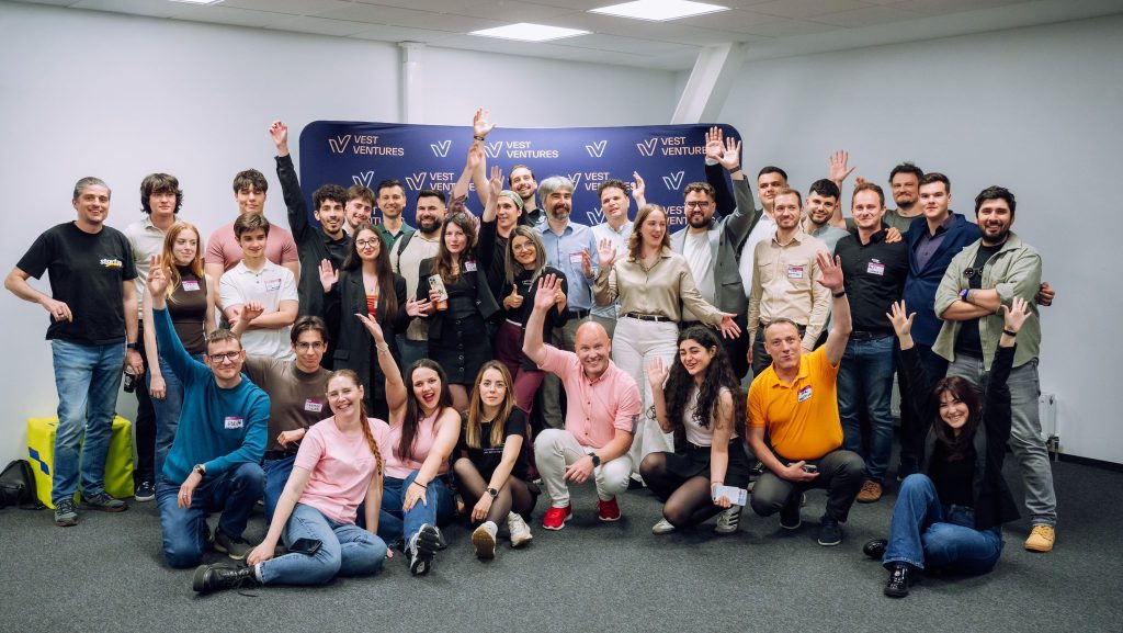 Tineri antreprenori prezentând un proiect de tehnologie în fața unui juriu de investitori la un eveniment din Timișoara.