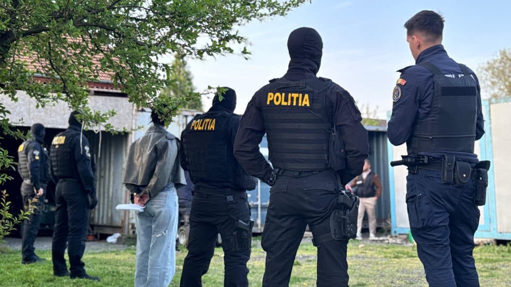 Polițiști din Timiș și mascați de la SAS ridicând panouri fotovoltaice și invertoare furate, în urma unor descinderi în satul Jena.