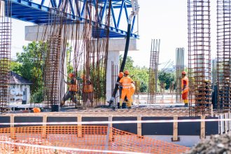 „Muncitori pe șantierul de la Gara de Nord din Timișoara, lucrând la armarea și cofrarea noii parcări subterane.”