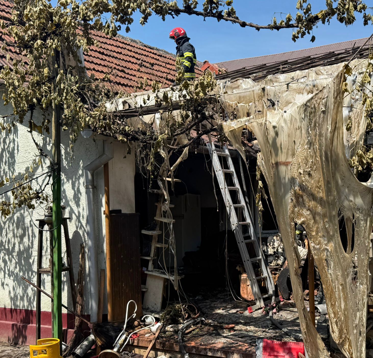 „Autospeciale ISU Arad intervenind de urgență în localitatea Sebiș pentru stingerea unui incendiu izbucnit după explozia unei butelii.”