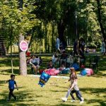 Copii și părinți participând la atelierele interactive organizate în aer liber în Parcul Copiilor din Timișoara.