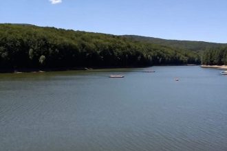 Vedere panoramică cu lacul de acumulare Trei Ape și barajul hidrotehnic înainte de începerea lucrărilor de golire.