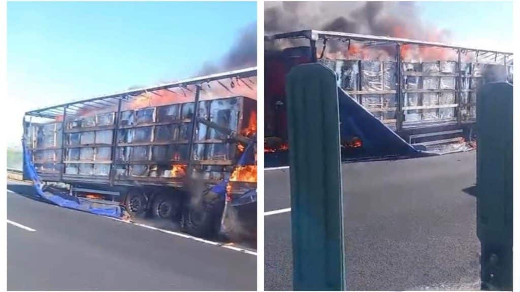 Semiremorcă de autotren cuprinsă de flăcări violente și coloană de fum negru pe banda de urgență a autostrăzii A1.