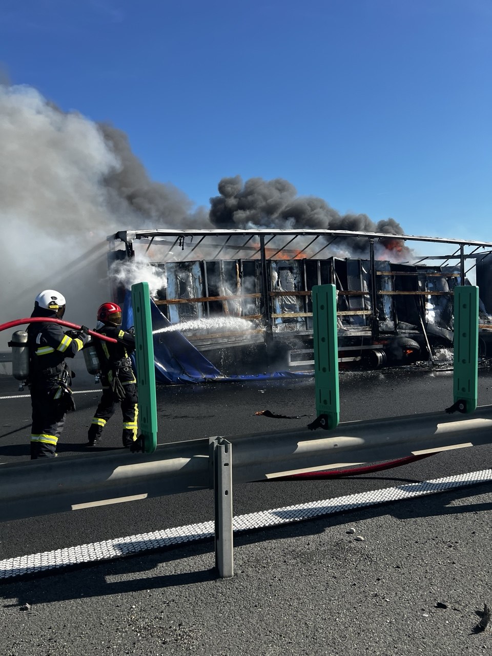 Semiremorcă de autotren cuprinsă de flăcări violente și coloană de fum negru pe banda de urgență a autostrăzii A1.