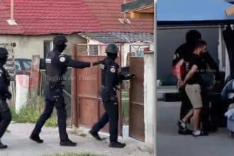 Mascați și polițiști de la Transporturi Feroviare blocând o stradă din Sânandrei în timpul executării unor mandate de percheziție domiciliară.