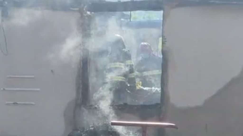 Autospeciale de stingere ale ISU Timiș intervenind cu furtunuri cu apă pentru lichidarea unui incendiu la o casă din mediul rural.