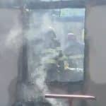 Autospeciale de stingere ale ISU Timiș intervenind cu furtunuri cu apă pentru lichidarea unui incendiu la o casă din mediul rural.