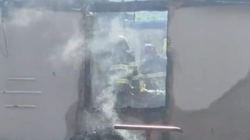 Autospeciale de stingere ale ISU Timiș intervenind cu furtunuri cu apă pentru lichidarea unui incendiu la o casă din mediul rural.