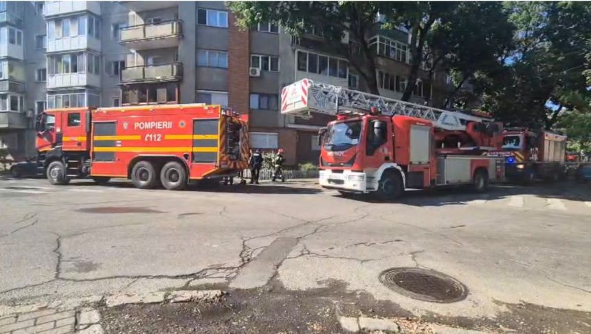 Autospeciale de stingere și autoscară mecanică ale Detașamentului 2 Pompieri Timișoara staționate în fața unui bloc de locuințe.