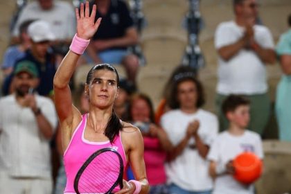 Jucătoarea română de tenis Sorana Cîrstea executând o lovitură puternică de pe linia de fund pe zgura de la Roland Garros.