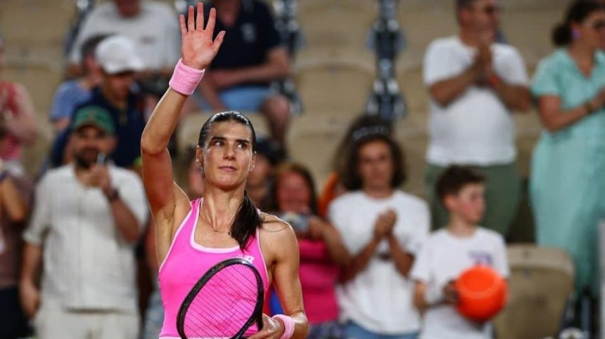 Jucătoarea română de tenis Sorana Cîrstea executând o lovitură puternică de pe linia de fund pe zgura de la Roland Garros.