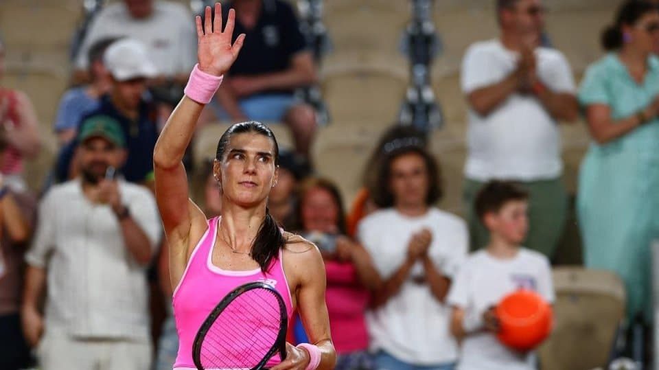 Jucătoarea română de tenis Sorana Cîrstea executând o lovitură puternică de pe linia de fund pe zgura de la Roland Garros.