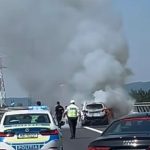 Autoturism cuprins în totalitate de flăcări pe banda de urgență a autostrăzii A1, în zona localității Ilia, generând o coloană groasă de fum negru.